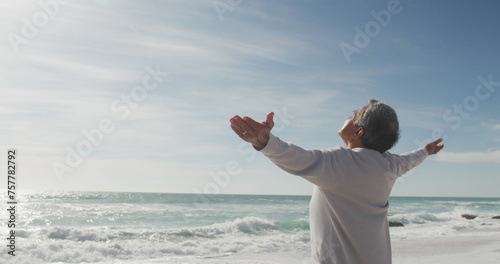 Senior biracial man enjoys freedom by the sea, with copy space