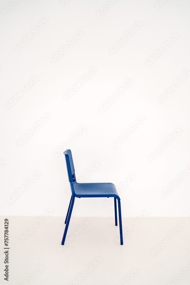 Minimalistic blue chair near a white wall Minimalistic blue chair near a white wall