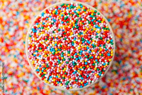 Confectionery sprinkles in bowl. Colorful background. Decoration for cake and bakery.