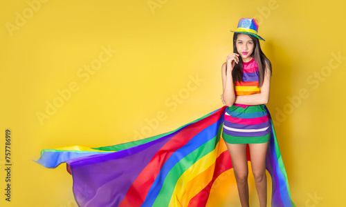 Asian woman with a rainbow flag and rainbow dress in  LGBTQ symbolic concept