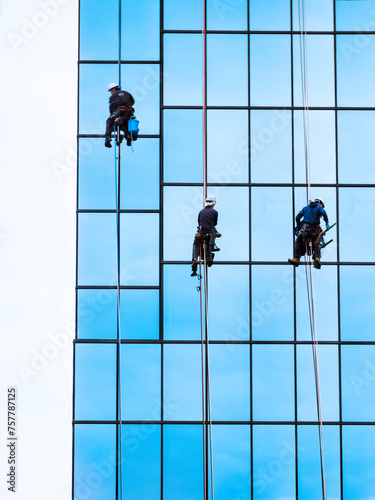 Exterior Building Cleaning Service Workers group clean window on high rise building © VTT Studio