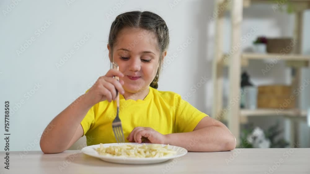Happy family concept.child sits at the kitchen table and eats pasta with fork. delicious appetizing lunch. happy child eats freshly prepared pasta. healthy eating. lunch snack. delicious lunch at home Happy family concept.child sits at the kitchen table and eats pasta with fork. delicious appetizing lunch. happy child eats freshly prepared pasta. healthy eating. lunch snack. delicious lunch at home