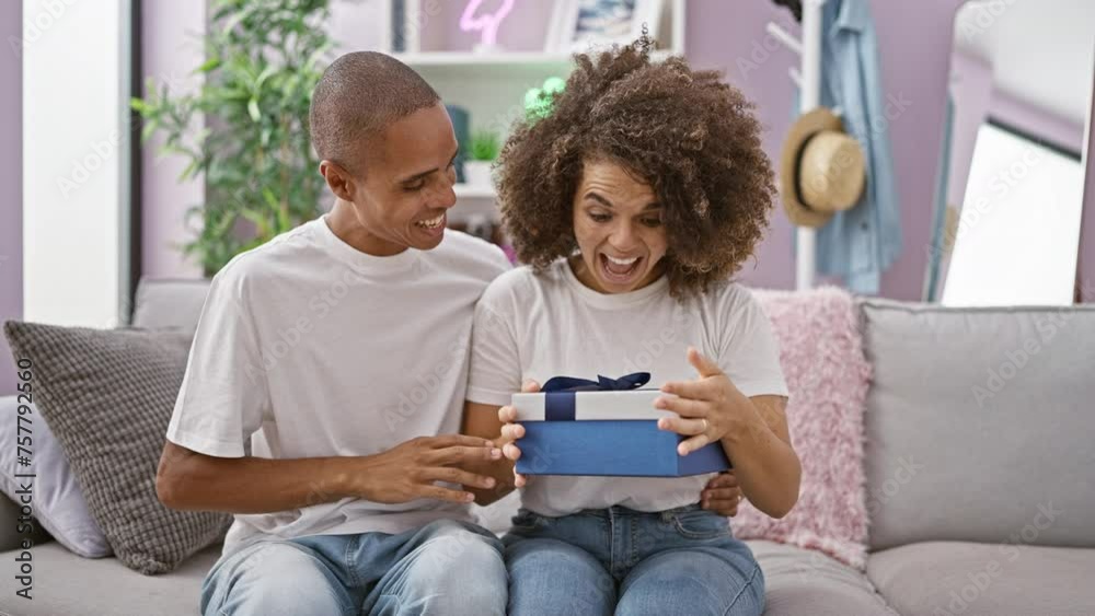 Beautiful couple enjoy fun times at home, the man covering the woman's eyes on the sofa for a lovely birthday surprise gift, smiling with confident love. Beautiful couple enjoy fun times at home, the man covering the woman's eyes on the sofa for a lovely birthday surprise gift, smiling with confident love.