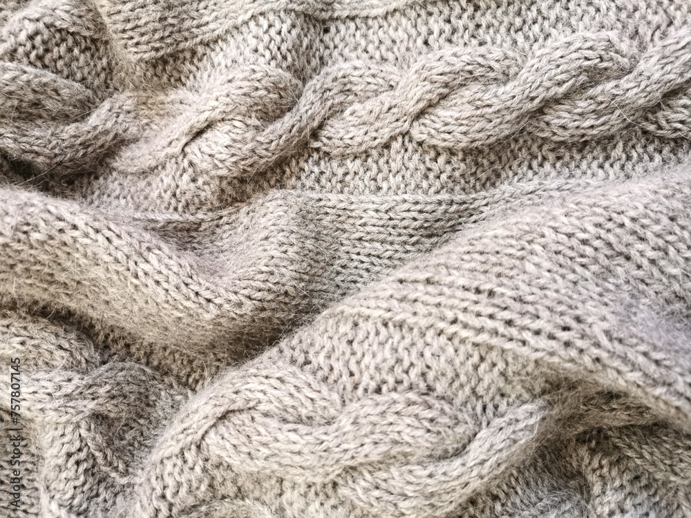 Knitted canvas handmade from gray natural fluffy cozy warm sheep yarn close-up winter texture background Knitted canvas handmade from gray natural fluffy cozy warm sheep yarn close-up winter texture background
