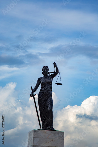 Sculpture of Lady Justice or Themis symbol of justice and law in Izmir Turkey, Femida outdoors against blue cloudy sky background copy space cut out vertical