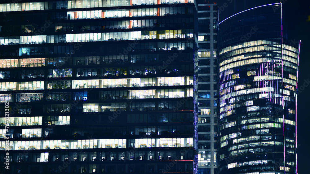 Office building at night, building facade with glass and lights. View with illuminated modern skyscraper. Office building at night, building facade with glass and lights. View with illuminated modern skyscraper.