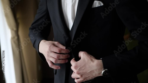 The man puts on a black jacket