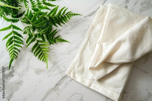 Fresh green fern leaves on a marble background. Textile fabric napkin.