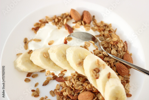 Greek Yoghurt Served with Freshly Baked Granola, Almonds, Seeds, Banana Slices. Healthy Breakfast.
