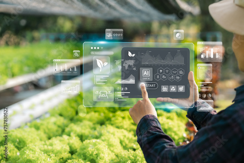 Agricultural technology concept, Ai system. A young man is working on a farm using a tablet controller with innovative technology for a smart farm system.