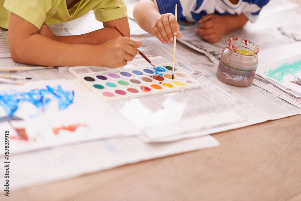 Children hands, palette and creative with paint brush on floor or playing, hobby and drawing together at home. Kids, motor skills and growth for childhood development with creativity for artwork Children hands, palette and creative with paint brush on floor or playing, hobby and drawing together at home. Kids, motor skills and growth for childhood development with creativity for artwork