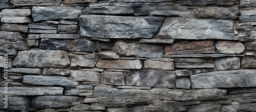 A detailed closeup of a stone wall constructed with various types of rocks, showcasing a beautiful composite material pattern. The rectangular bricks and bedrock create a stunning brickwork design