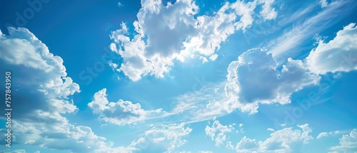 The sky is blue with many clouds. The clouds are scattered throughout the sky and some are larger than others. The sun is shining brightly, making the sky look bright and cheerful