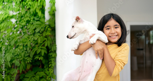 happy asian kids hug her puppy at home as human relationship with pet