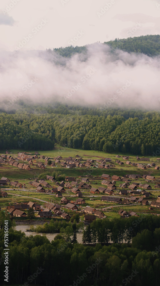 Hemu village on Kanas Nature Reserve, enveloped in fog. - obrazy, fototapety, plakaty 