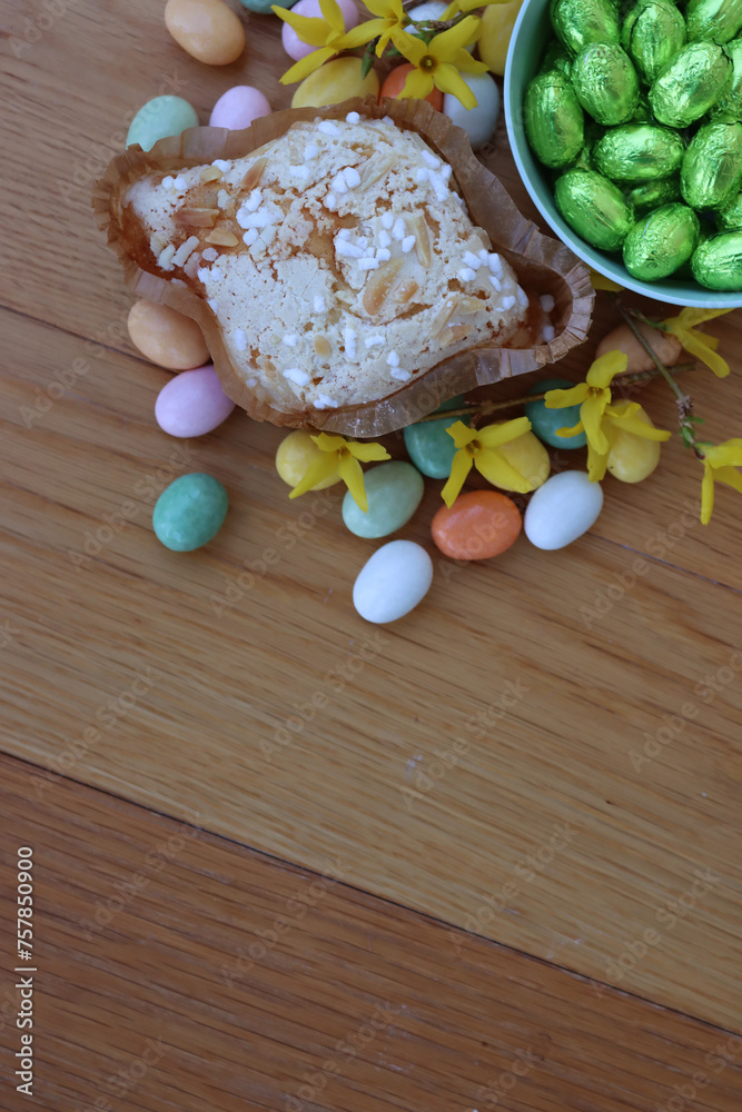 Sweet Easter cake named Colomba Pasquale with colorful chocolate eggs and yellow Forsythia flowers . Italian traditional pastry on wooden table Sweet Easter cake named Colomba Pasquale with colorful chocolate eggs and yellow Forsythia flowers . Italian traditional pastry on wooden table