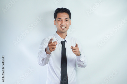Adult Asian man showing excited expression while pointing finger forward photo