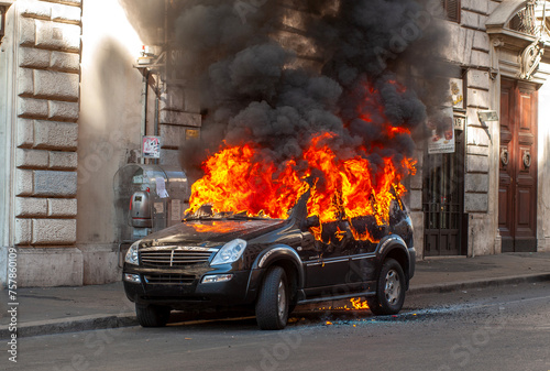 Burning suv car damaged in isolated city street before being rescued by firefighters for explosion danger © Lorenzo Dottorini