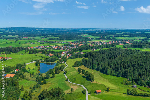 Der idyllisch gelegene Biberschwoller See am oberbayerischen Alpenrand im Sommer