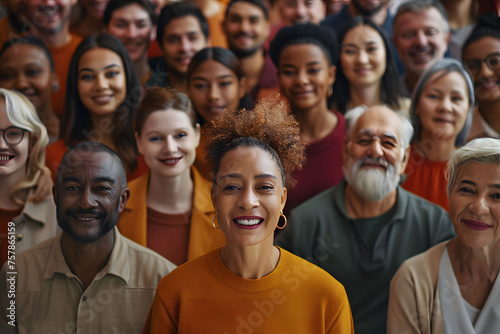 A large diverse group of people, including men and women from various ethnic backgrounds, are depicted smiling and facing the camera in an overhead shot. © jex