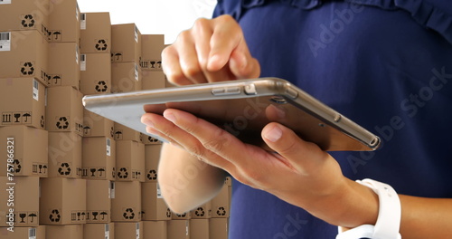 Image of man using tablet with stacks of boxes on white background