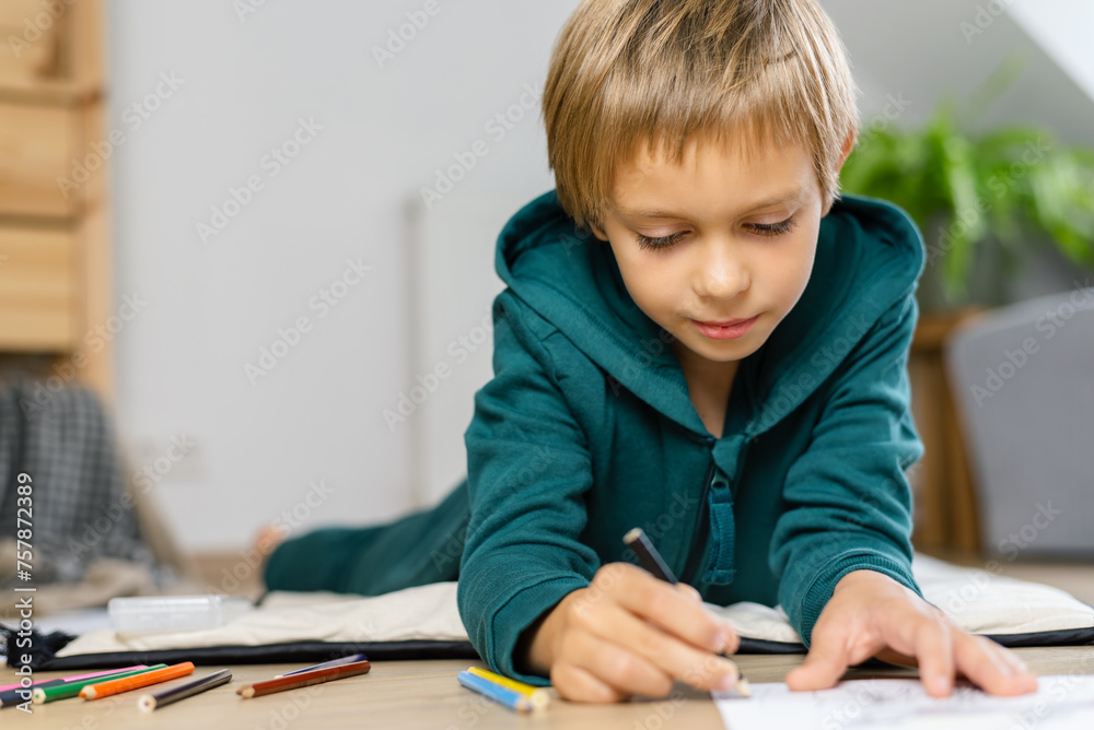 Boy drawing in on the floor a cozy room. Boy drawing in on the floor a cozy room.