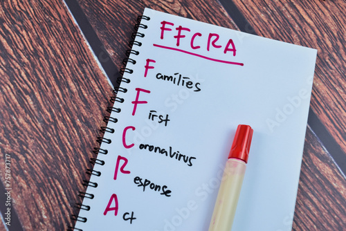 Concept of FFCRA - Families First Coronavirus Response Act write on book isolated on Wooden Table. photo