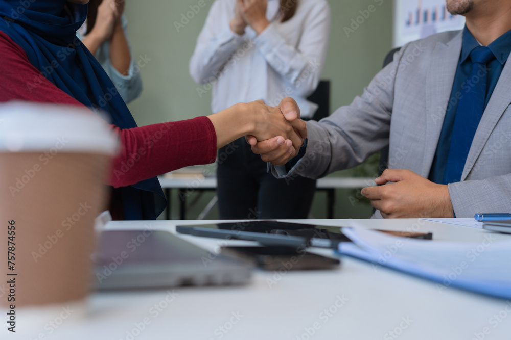 Happy businessman and businesswoman shaking hands at group board meeting. Professional business executive leaders making handshake agreement successful company trade partnership handshake concept. Happy businessman and businesswoman shaking hands at group board meeting. Professional business executive leaders making handshake agreement successful company trade partnership handshake concept.
