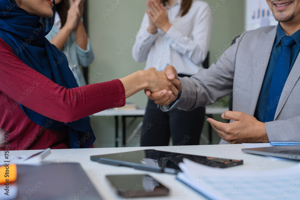 Happy businessman and businesswoman shaking hands at group board meeting. Professional business executive leaders making handshake agreement successful company trade partnership handshake concept.