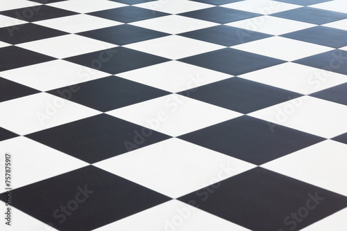 Top view of a floor made of large black and white ceramic tiles. Arranged in a checkerboard pattern. Background.