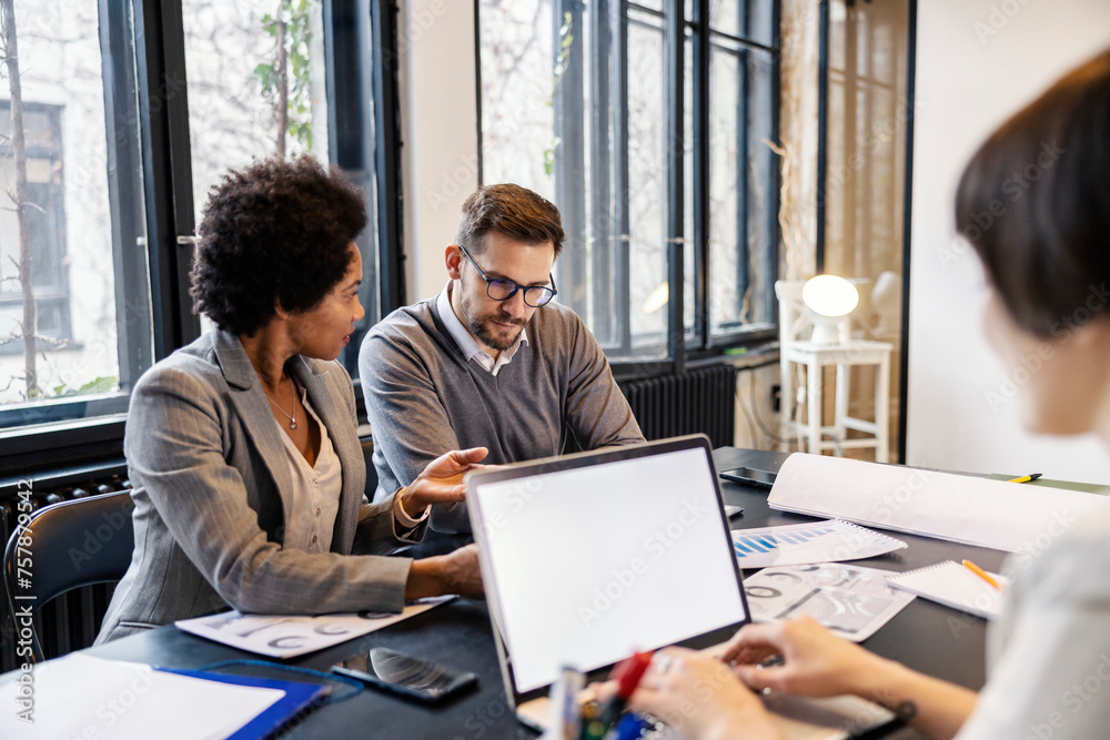Multicultural businesspeople in boardroom having briefing and analyzing statistics. Multicultural businesspeople in boardroom having briefing and analyzing statistics.