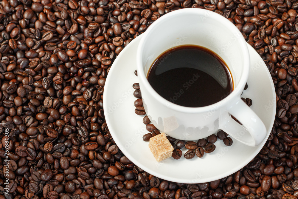 A cup of coffee with coffee beans and sugar cubes. A cup of coffee with coffee beans and sugar cubes.