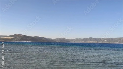 A blue lake with waves and beautiful mountains on the horizon