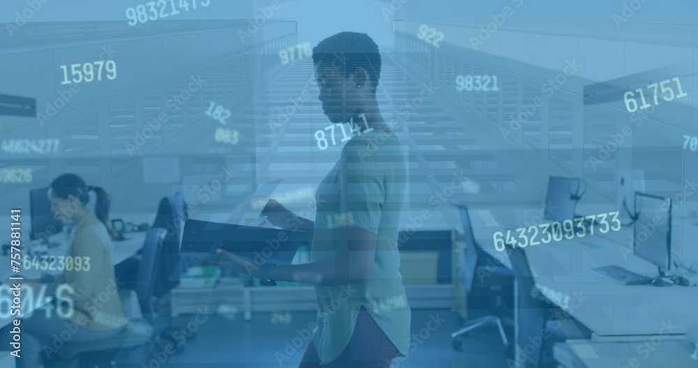 Image of numbers over african american woman in office Image of numbers over african american woman in office