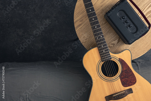 Acoustic guitar and speaker on the table, top view, copy space.