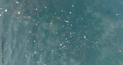 Top down drone shot of polluted water filled with plastic trash and dead coral reef in the turqouise tropical water of Balangan Beach Uluwatu Bali Indonesia photo