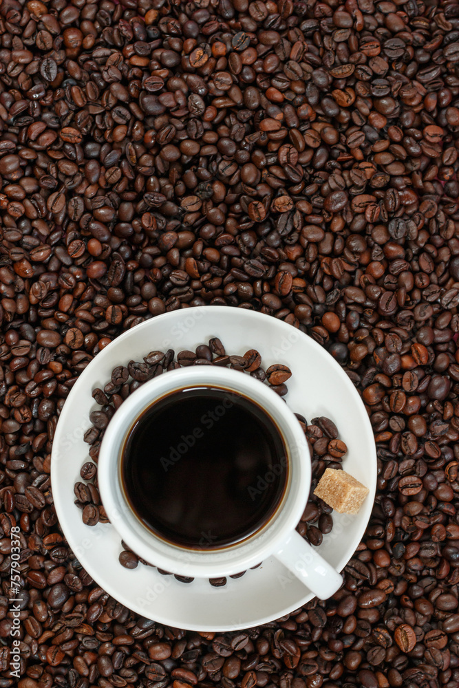 A cup of coffee with coffee beans and sugar cubes. A cup of coffee with coffee beans and sugar cubes.