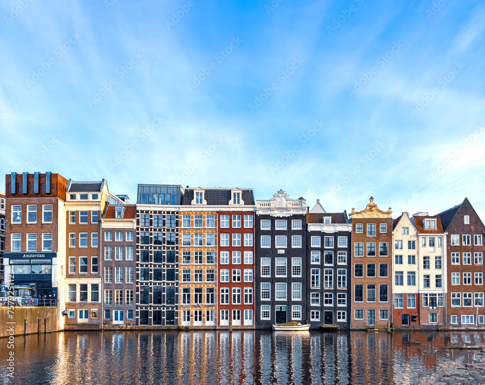 Traditional Dutch construction buildings on Damrak canal in Amsterdam in winter