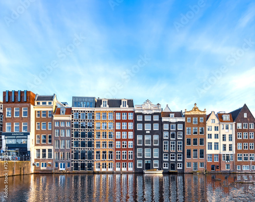 Traditional Dutch construction buildings on Damrak canal in Amsterdam in winter
