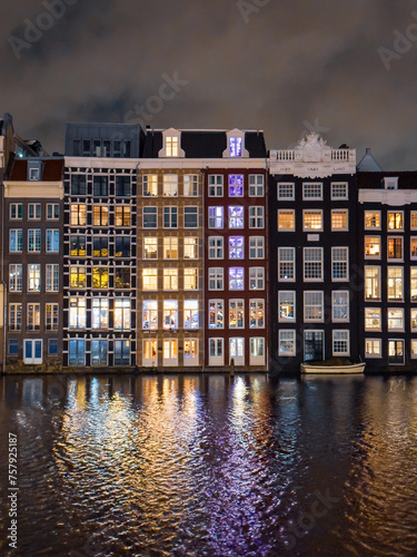 Canvas Print Traditional Dutch construction buildings on Damrak canal at night in Amsterdam i