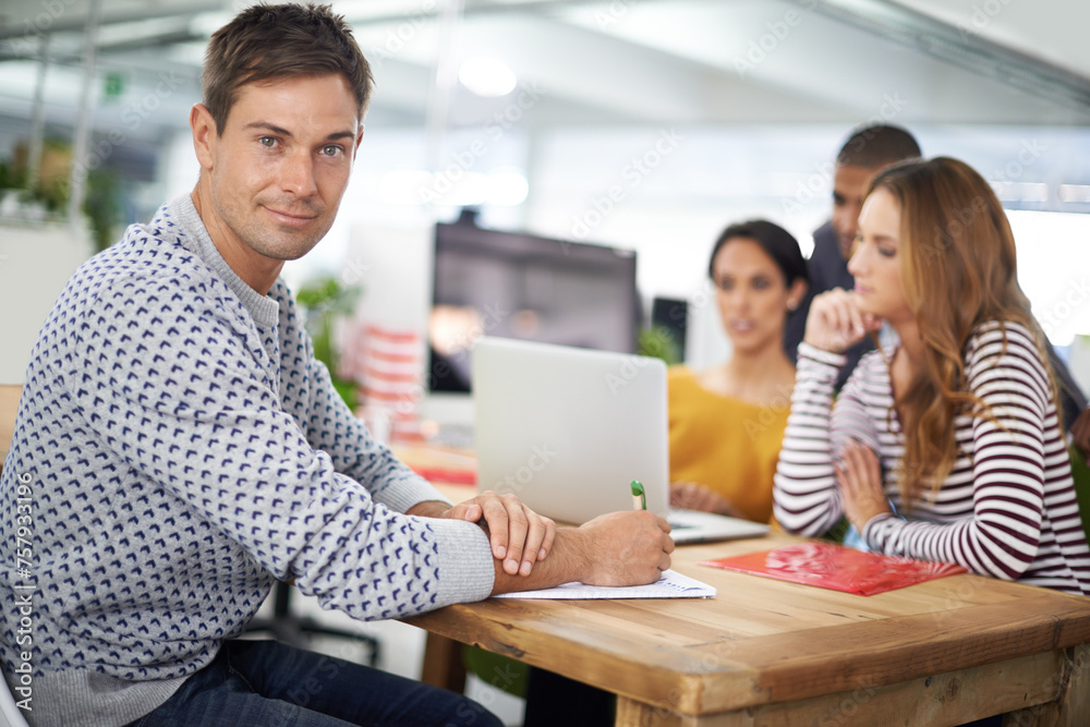 Man, portrait and smile at desk with meeting for business or creative company, planning and teamwork. Male person or designer, office and collaboration for startup agency, paperwork and documents.