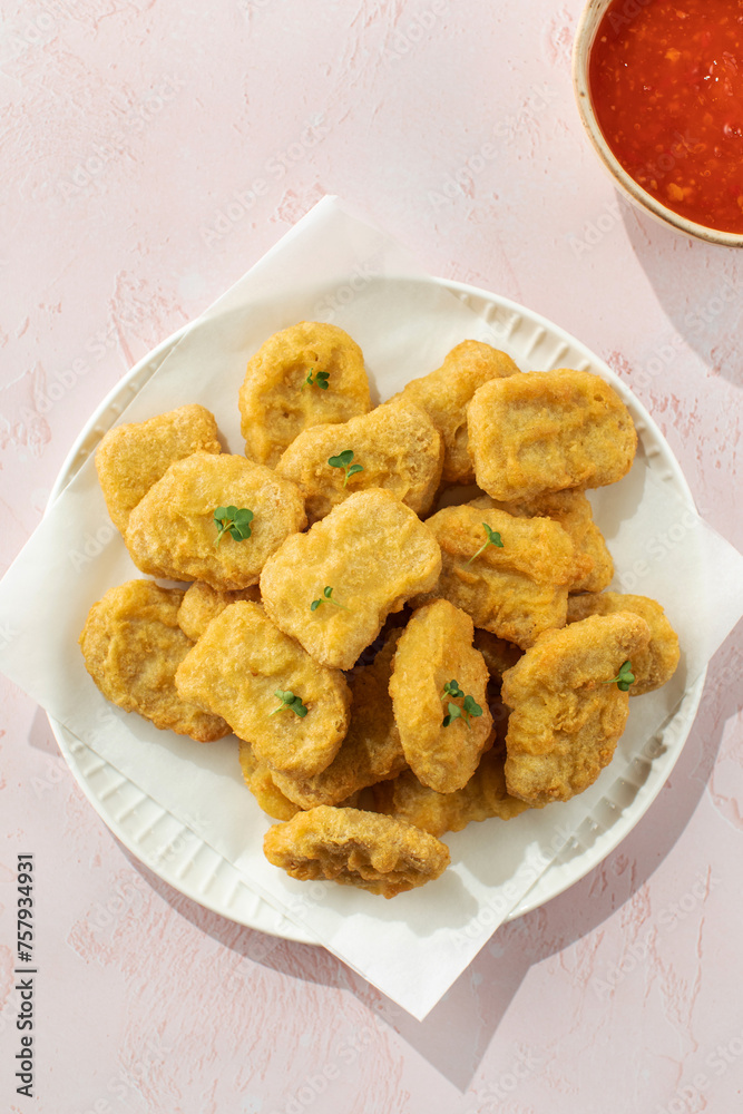 Delicious golden chicken nuggets on a plate on the table. Fast food, menu. Delicious golden chicken nuggets on a plate on the table. Fast food, menu.