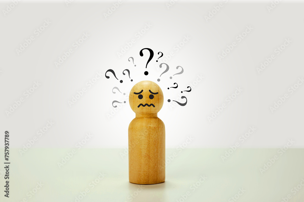 Sad-looking wooden puppet Question mark on the head on a white ...