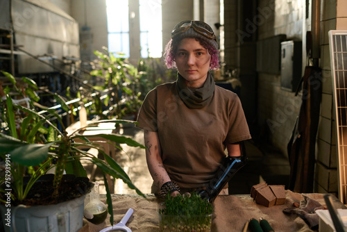 Εκτύπωση καμβά Medium shot of young Caucasian woman with prosthetic arm standing at table in po