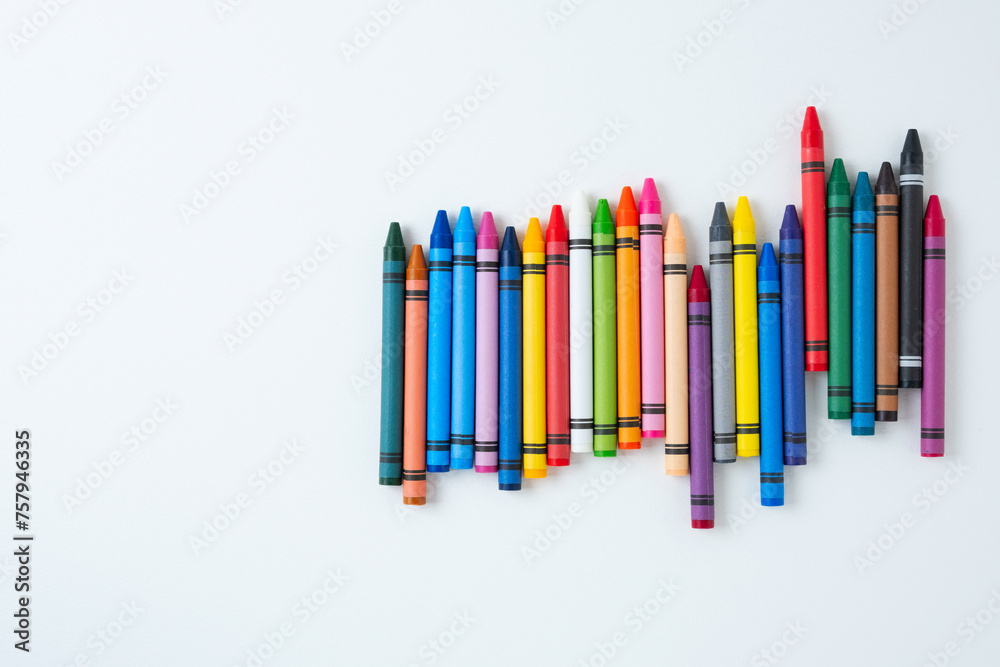 A large set of multi-colored children's wax crayons on a white background. A large set of multi-colored children's wax crayons on a white background.