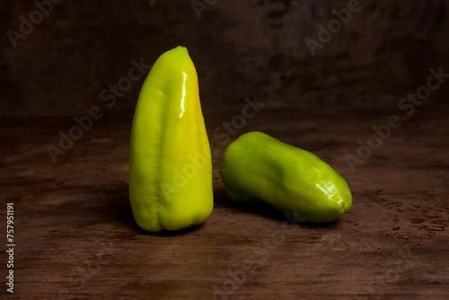 Two green bell pepper on wooden background. .