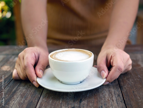 Hot cappuccino cup in hand,Woman Hand Holding Coffee capucino