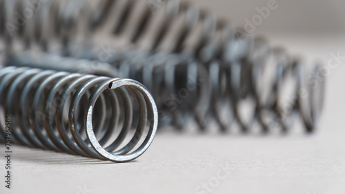 Coiled metal spring on metal surface, close-up view
