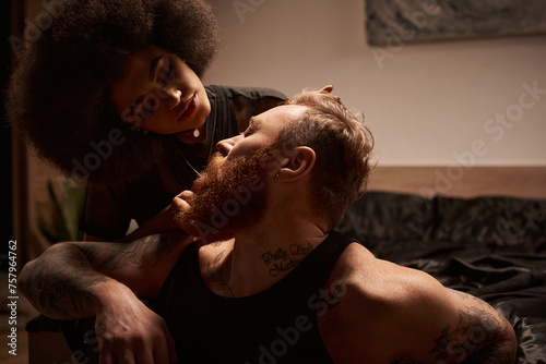 Obraz na plátne african american woman looking at  her boyfriend with beard and tattoos in dark
