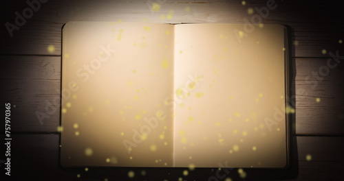 Image of yellow glowing spots over open book with copy space
